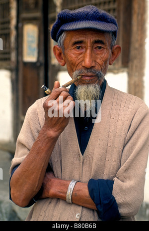 1, one, Chinese man, Bai man, ethnic minority, old man, smoking tobacco, smoking pipe, eye contact, front view, Shaping, Yunnan Province, China Stock Photo