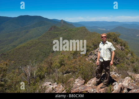 Male hiker standing on a rocky ridge in the Cathedral Ranges, Victoria, Australia Stock Photo