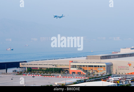 An airplane arrives at Hong Kong Chek Lap Kok Airport next to Asia World Expo in Hong Kong Stock Photo