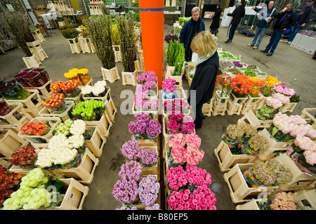 A woman looks through a selection of flowers at London's New Covent Garden Flower Market London UK Stock Photo