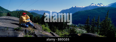 A Female Hiker contemplating the View of the Tantalus Mountain Range near Whistler and Squamish British Columbia Canada Stock Photo