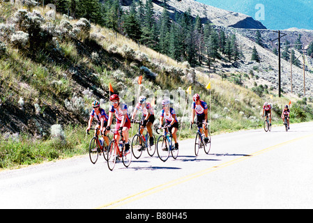 A Group of Cyclists cycling Uphill on a Paved Highway in the Mountains British Columbia Canada Stock Photo