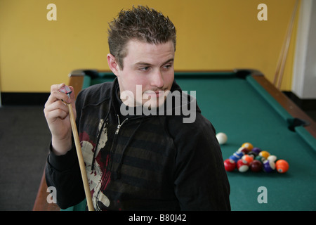 Young man chalking his pool stick. Stock Photo