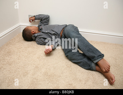 5 year old boy having a tantrum and sulking Stock Photo