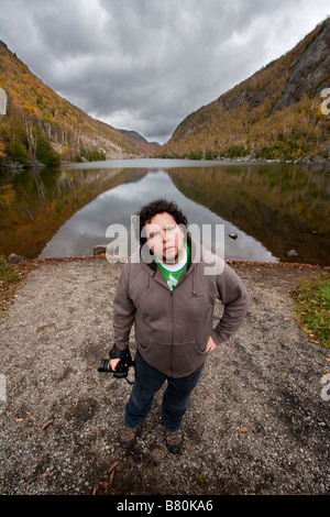 A man holding a camera standing in front of a lake in the Adirondacks of New York October 6 2008 MR YES Stock Photo