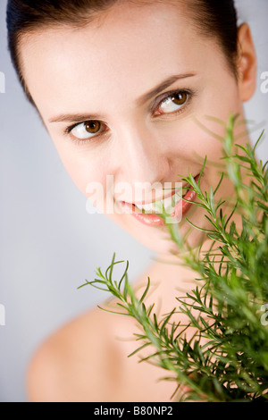 Young woman holding bunch of rosemary smiling head and shoulder Stock Photo