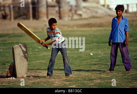 Two Indian boys playing cricket on the dried up lake Pichola in Udaipur Stock Photo