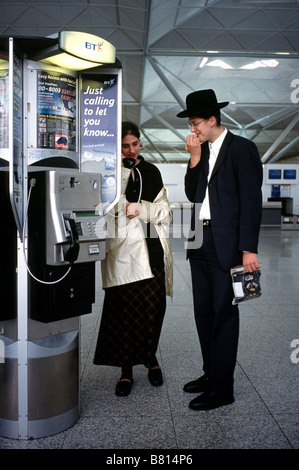 Oct 7, 2003 - Orthodox Jews calling home from a public BT payphone inside Stansted airport's departure hall. Stock Photo