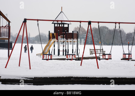 Playground equipment in snow, St Nicholas Park, Warwick, Warwickshire, England, UK Stock Photo
