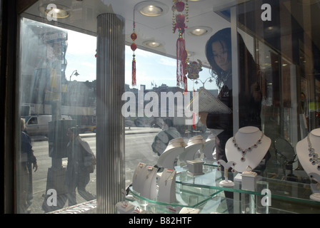 A worker in a jewelry store in Chinatown in New York inspects the window display on Friday January 23 2009 Richard B Levine Stock Photo