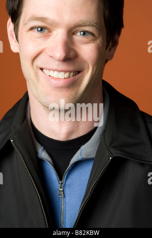 Portrait of an attractive man smiling on a plain background Stock Photo