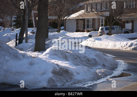 Dirty melting Snow on the side street/Road with Houses at the back in Scarborough Toronto Stock Photo