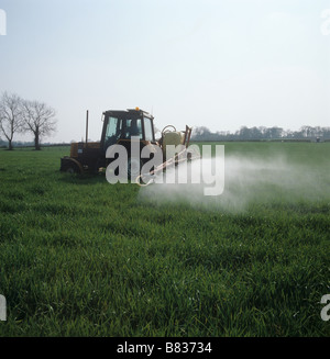 Renault tractor with a Hardi sprayer spraying a young barley crop in spring Stock Photo