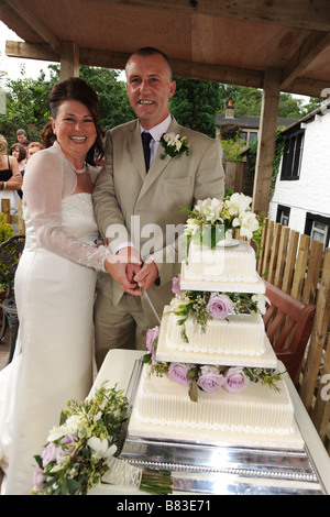 A Newly wed couple cut their wedding cake, North Yorkshire, Model Released Stock Photo