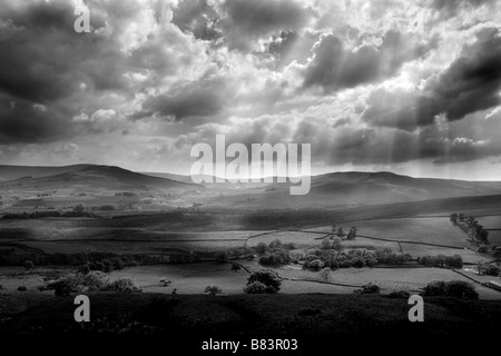 The sun bursts through the clouds near Hawes in Wensleydale, Yorkshire Dales, UK Stock Photo