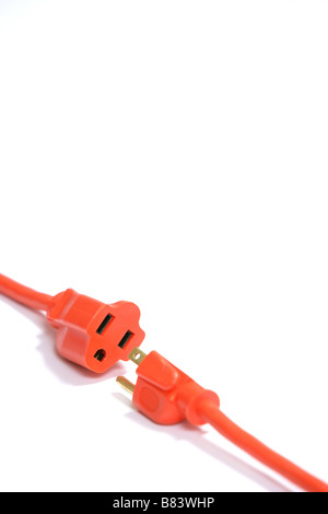 A 100 foot orange extension cord coiled up with a three way splitter Stock Photo