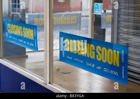 Posters in a shop window advertising the shops impending closure Stock Photo