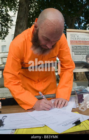 Man in orange jumpsuit signs petition for release of Binyam Mohamed, still in Guantamo Bay at Whitehall protest on his birthday Stock Photo