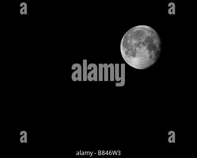 The Moon shining brightly displaying full detail of the lunar landscape on a winters evening over the river clyde in Scotland Stock Photo