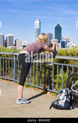 A young woman doing stretching exercises in King's Park, Perth, Western Australia Stock Photo