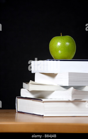 An apple on top of a stack of books Stock Photo