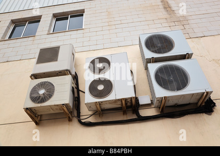 Group of air conditioning machines on wall outside business premises Stock Photo
