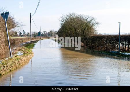 Country road under water following recent flash flooding caused by snow melt Stock Photo