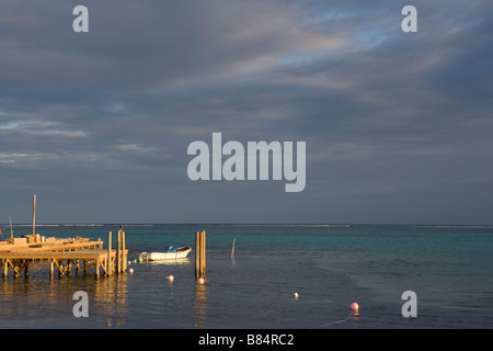 A small boat and pier with a view to the breakers and waves on the horizon on Ambergris Caye in Belize. Stock Photo