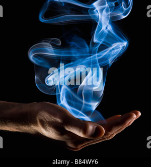 Smoke rising from a hand Stock Photo
