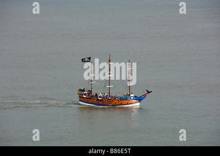 Pirate themed tourist passenger boat flying a black Jolly Roger flag. South Bay. Scarborough. North Yorkshire. UK Stock Photo