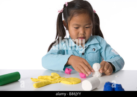 Little girl is modelling with clay Stock Photo