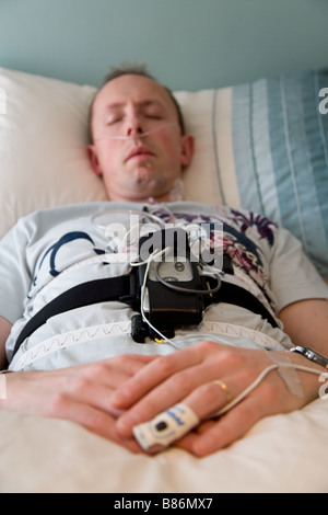 A man sleeping during an overnight home based sleep study wearing a ...