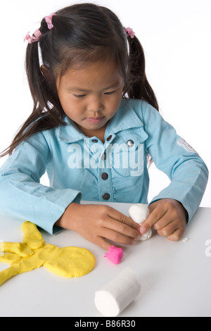 Little girl is modelling with clay Stock Photo