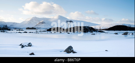 panorama of winter scenery at Ranoch Moor in Highlands of Scotland with a frozen and snow covered loch, mountains and lone tree. Stock Photo