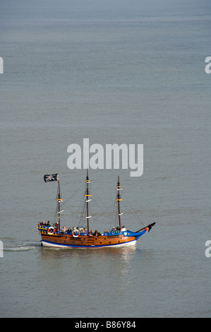 Pirate themed tourist passenger boat flying a black Jolly Roger flag. South Bay. Scarborough. North Yorkshire. UK Stock Photo