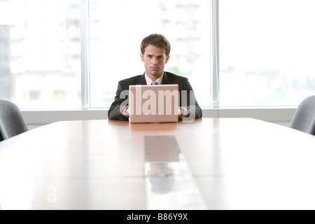 Businessman using laptop by table Stock Photo