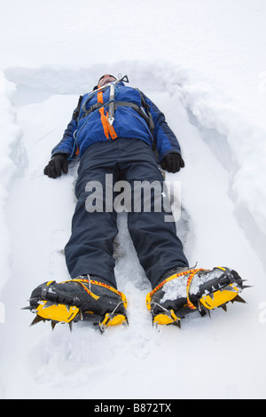 A man lying in the snow on Crinkle Crags in the Lake District UK Stock Photo