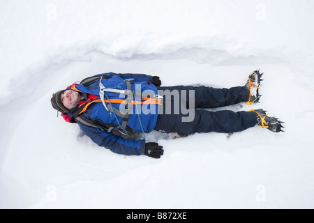 A man lying in the snow on Crinkle Crags in the Lake District UK Stock Photo