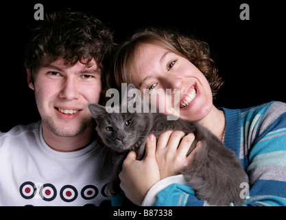 two people with a cat Adult Male and Adult Female with a grey cat studio Stock Photo