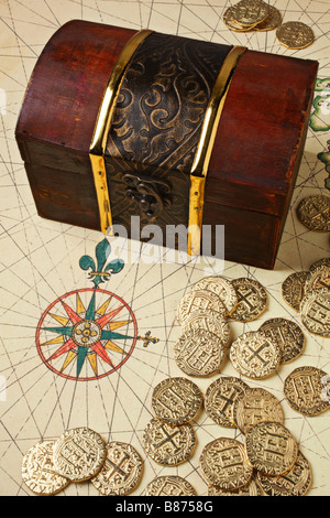 Treasure chest on map with rose compass and gold coins Stock Photo