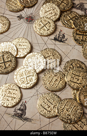 Gold coins doubloons on very old map Stock Photo