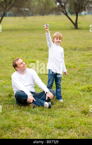Father looking at his son playing paper plane Stock Photo