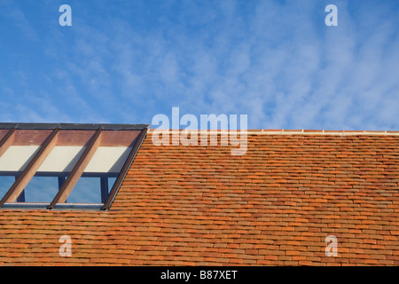 Red Clay Tiled Roof, Against A Blue Sky, With A glass Roof Light. Stock Photo