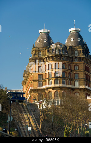 Decorative cornice and slate tiled cupolas of the curved facade of The Grand Hotel, with St Nicholas Cliff lift to the left. UK Stock Photo