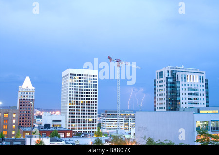 Lightning strikes during thunderstorm between buildings downtown Tacoma Washington Stock Photo
