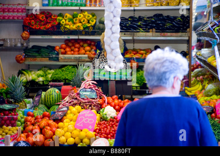 An elderly woman shops for vegetables in a produce stand in Venice italy Stock Photo