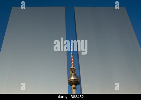 The Fernsehturm television tower in Berlin seen through the steel pillars celebrating the workers movement on Marx Engels Forum Stock Photo