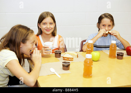 A group of school children having lunch in the school cafeteria Stock Photo