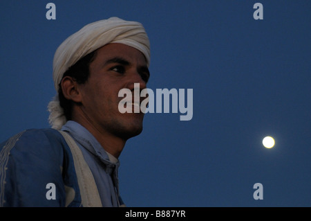 Bedouin in the sand desert with the horizon the blue sky and the full moon Merzouga Morocco Africa Stock Photo