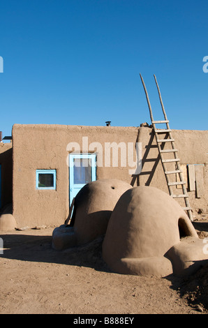 Inhabited adobe house with two beehive earthen ware ovens Taos Pueblo New Mexico USA Stock Photo